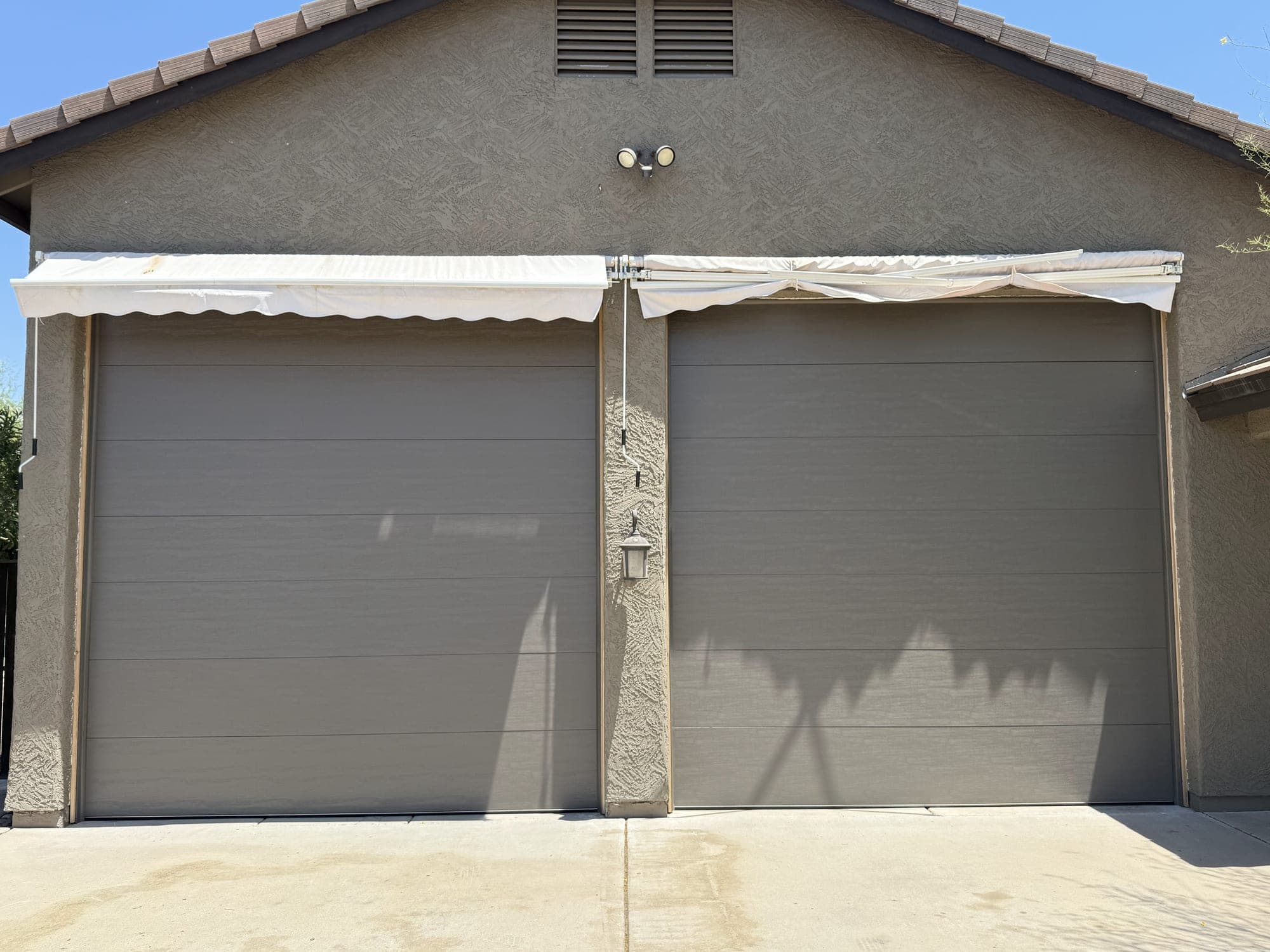 Garage Door Repair Glendale Two new grey flush-panel garage doors installed on a Glendale, AZ home by Desert Spring Garage Door Repair