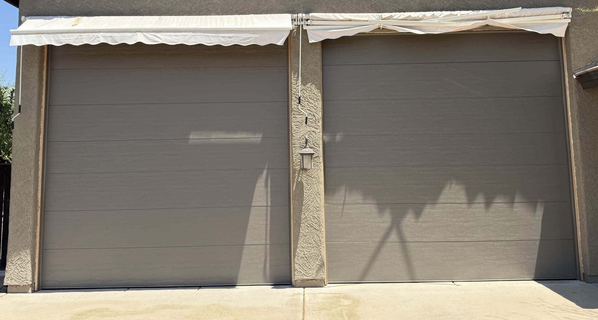 New grey flush-panel garage doors installed on a Glendale, AZ home by Desert Spring Garage Door Repair