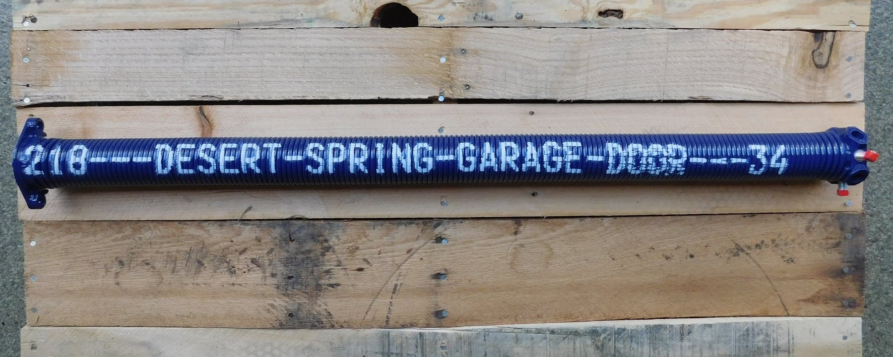 A custom cobalt Desert Spring Performance Spring stenciled 218 DESERT SPRING GARAGE DOOR 34, showing the wire-size and length markings